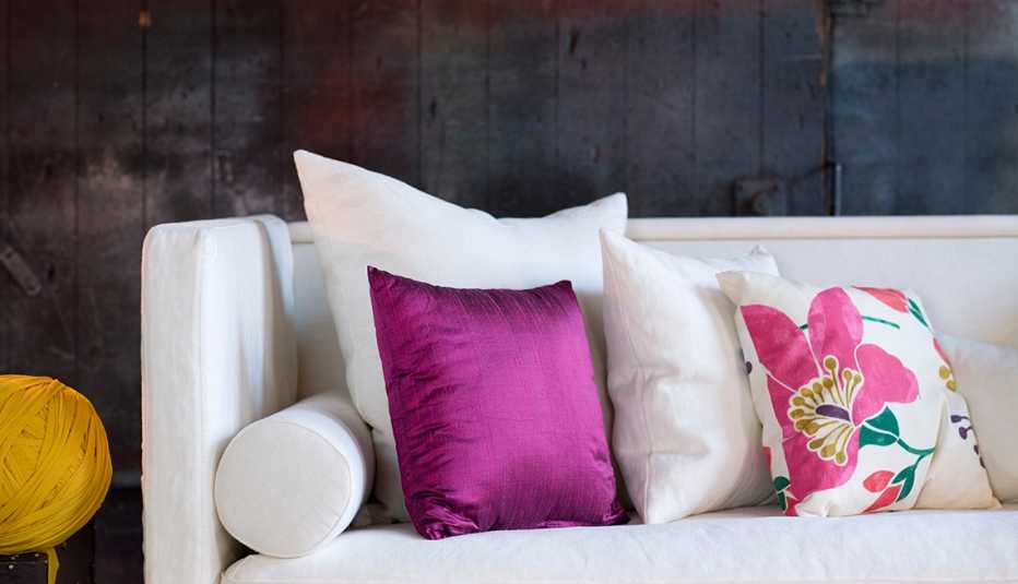 Sofá blanco decorado con cojines de colores