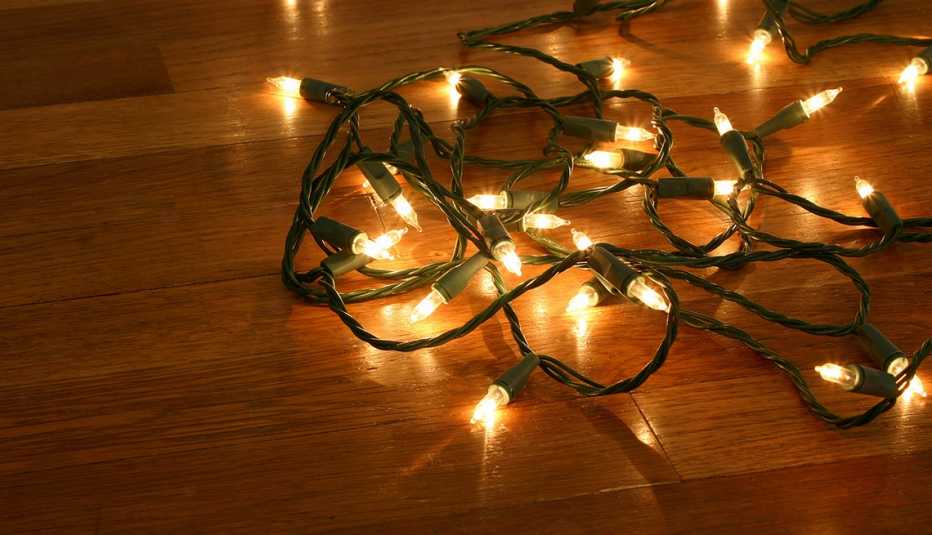 Extensión de luces de Navidad sobre un piso de madera