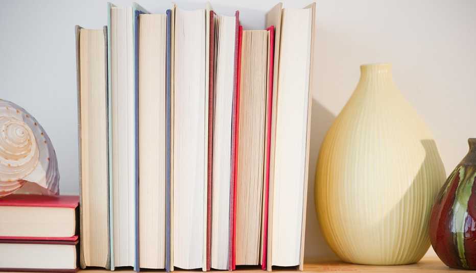 Varios libros colocados en forma vertifcal sobre un tablón de madera