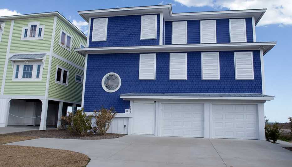 Casa de dos pisos color azul con contraventanas