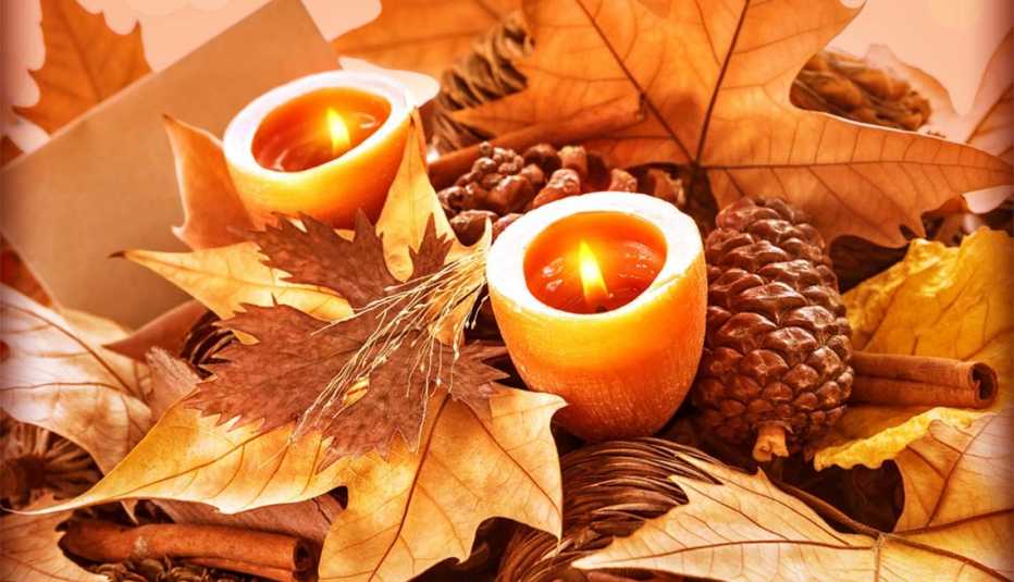 Hojas de otoño con conos de pino, velas y astillas de canela