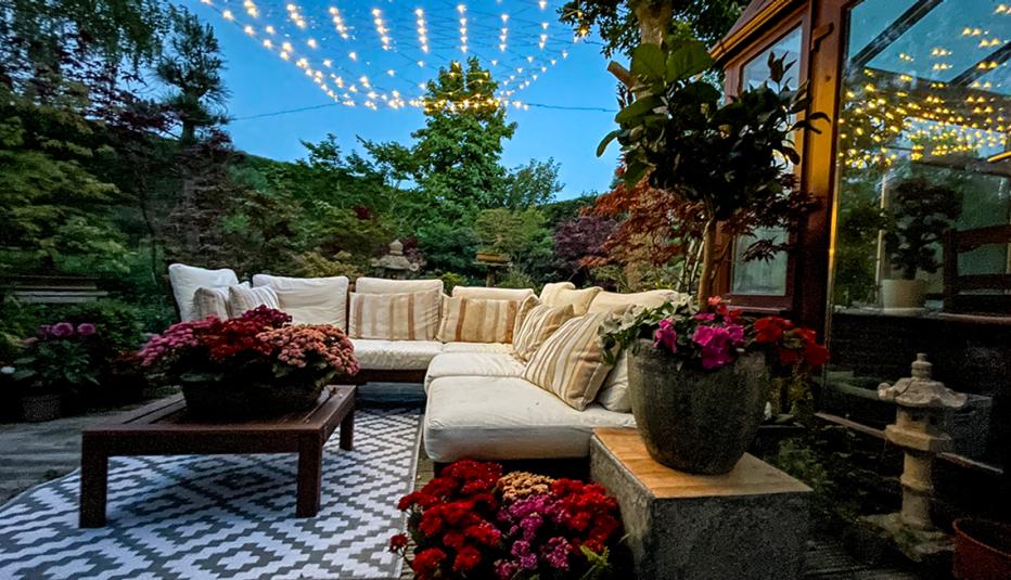  un patio al aire libre de verano iluminado con luces de cuerda