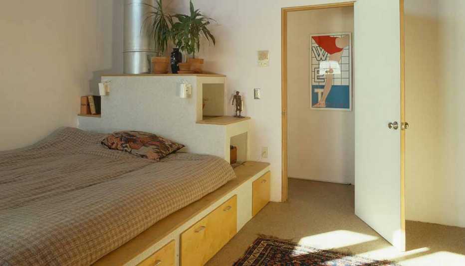Habitación de colores neytros y una cama sencilla 