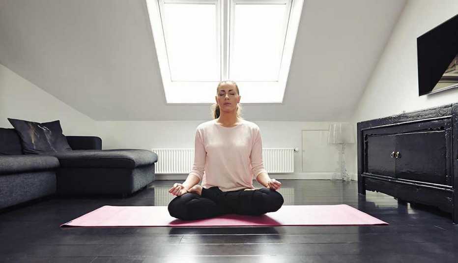Mujer meditando en un ático