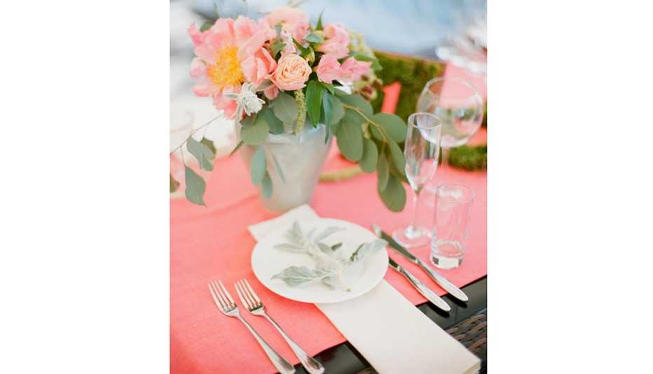 Mesa decorada con flores sobre un mantel color salmón