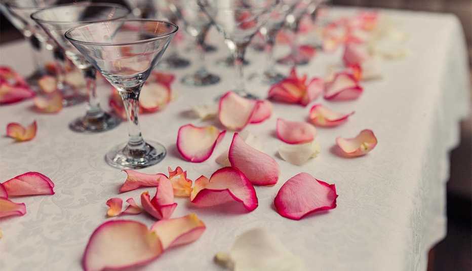 Pétalos de rosas sobre una mesa con copas