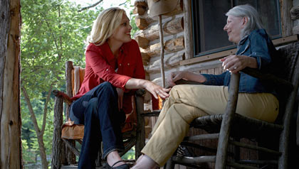 Dos mujeres conversan mientras están sentadas fuera de la casa