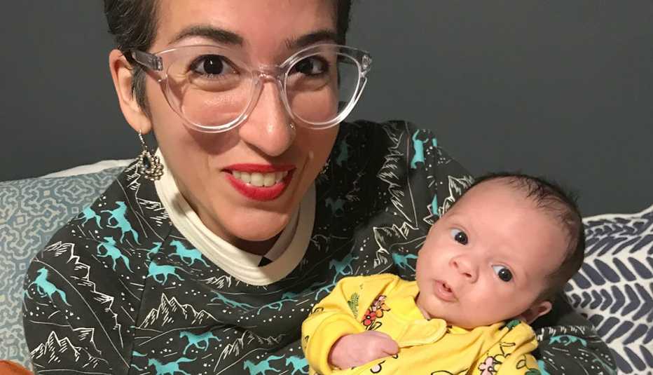 Vanessa García sonríe mientras sonstiene en los brazos a su hija adoptada