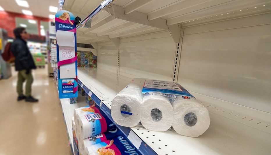 Estantes de un supermercado con pocos rollos de papel para el baño.