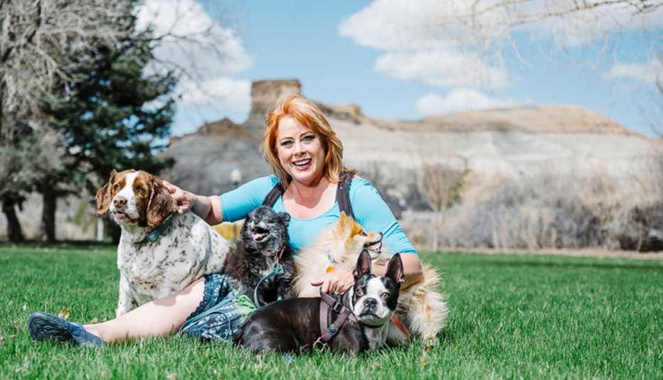 Mujer fotografiada con sus perros en el pasto