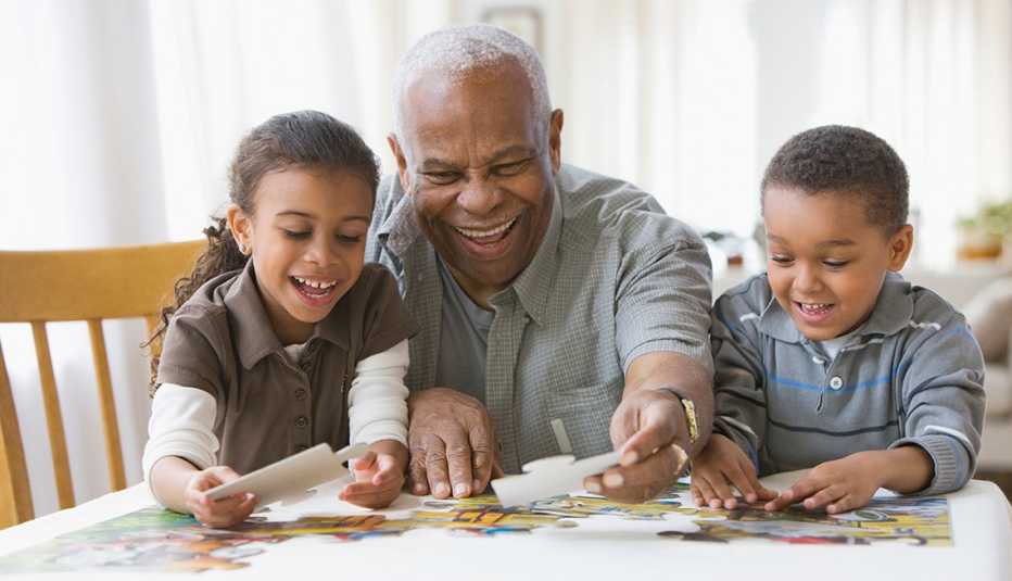 Abuelo con los y nietos construyendo un rompecabezas