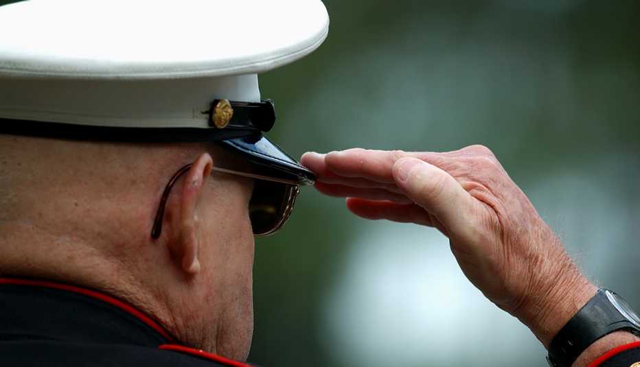 Un veterano con uniforme de la marina de EEUU saluda