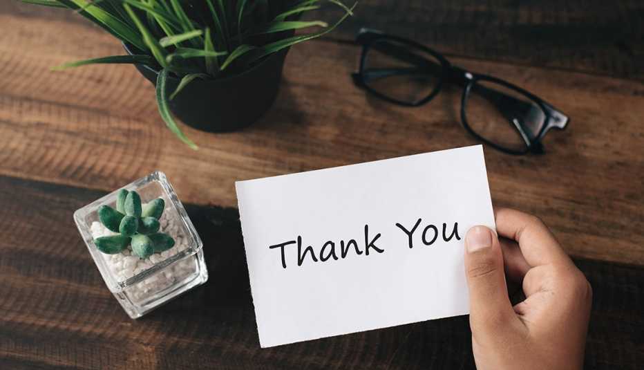 Persona sostiene una nota que dice thank you