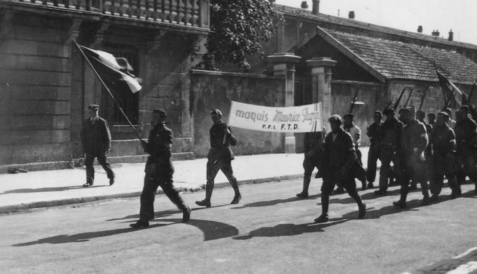 Hombres de la resistencia francesa marchan por la calle