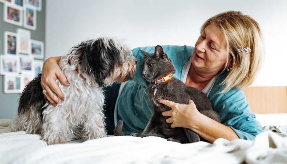 Mujer con un gato y un perro sobre su cama