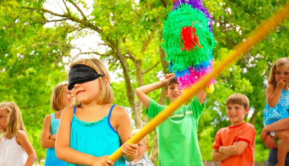 Niños juegan a romper una piñata