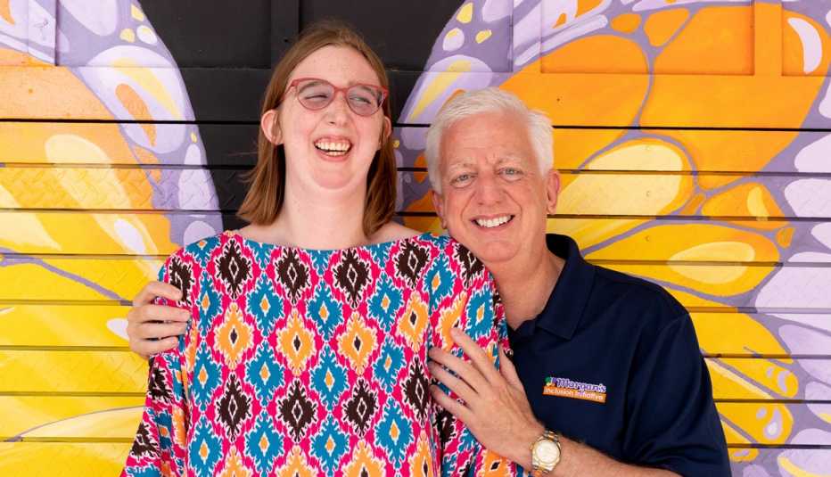 Gordon Hartman y su hija Morgan frente a un mural de mariposas