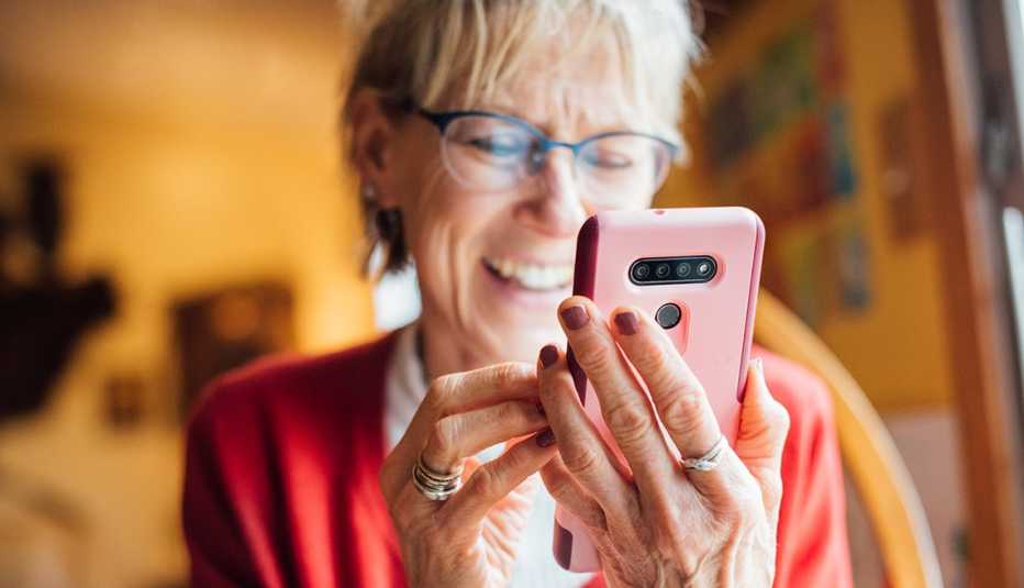 Mujer sonriente jugando a un videojuego en su smartphone
