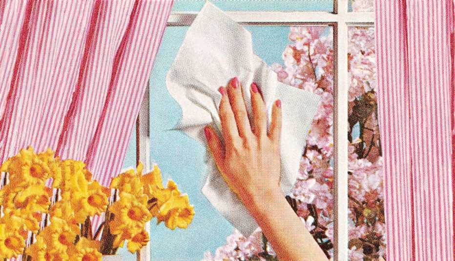 La mano de una mujer limpiando una ventana.