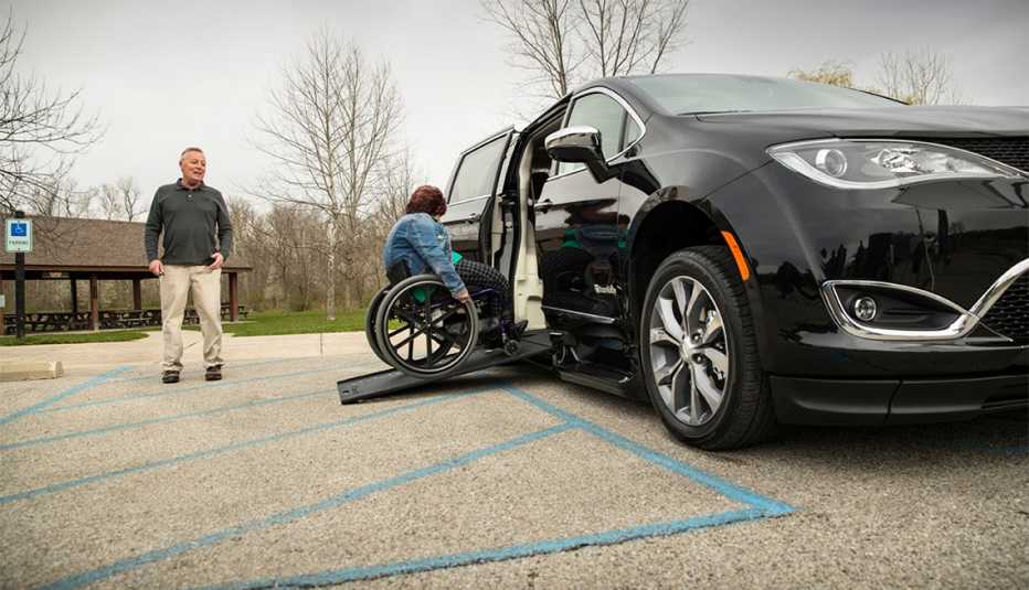 Mujer rueda su silla de ruedas adaptada por BraunAbility en un Chrysler Pacifica