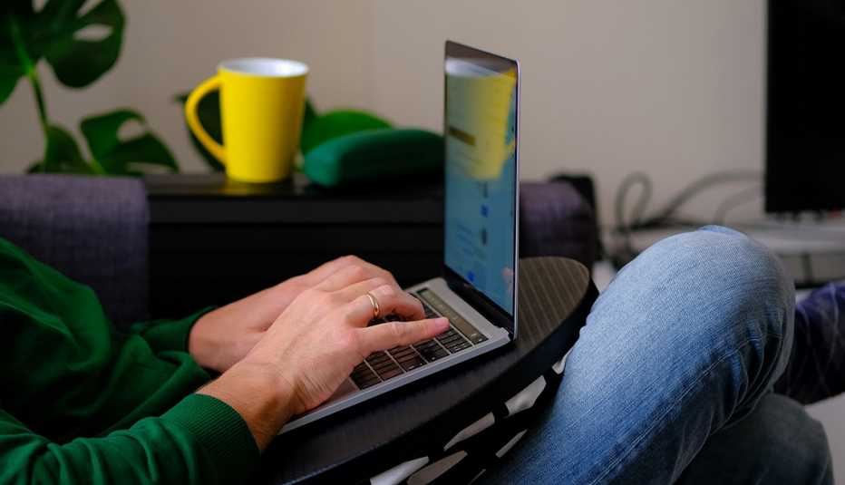 Un hombre se inclina hacia atrás mientras revisa su computadora portátil