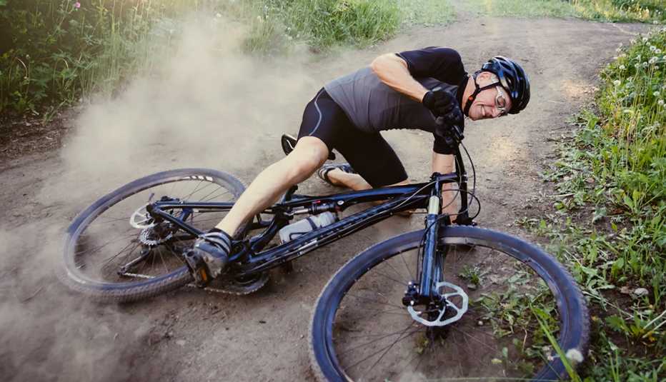 Hombre en bicicleta de montaña se cae en un sendero