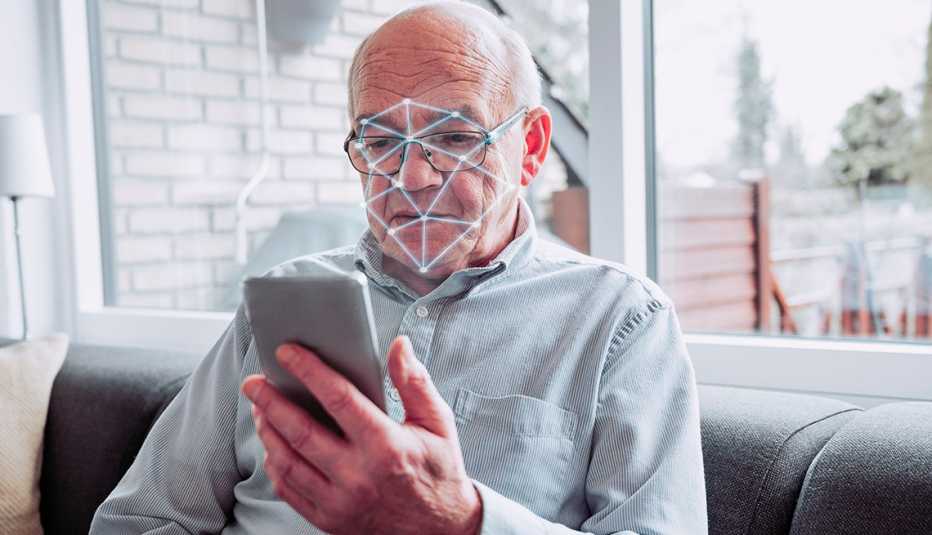 Un hombre sostiene un teléfono que escanea su rostro
