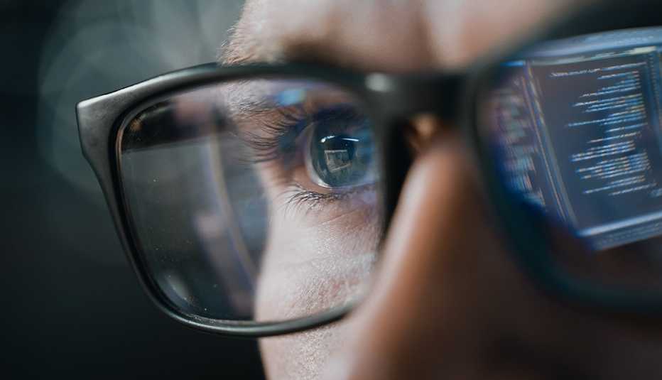 Persona con anteojos observa una computadora
