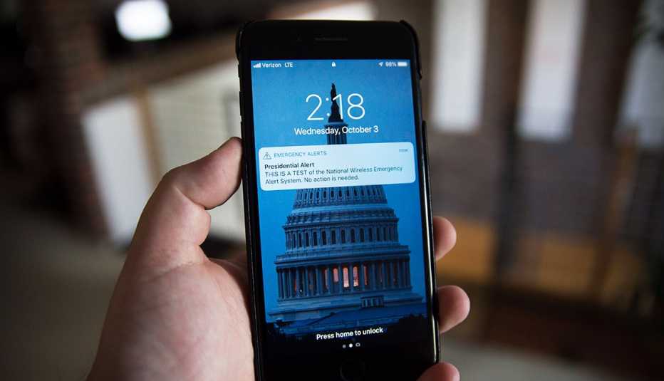 una alerta aparece en un teléfono inteligente que tiene una imagen de fondo del edificio del capitolio