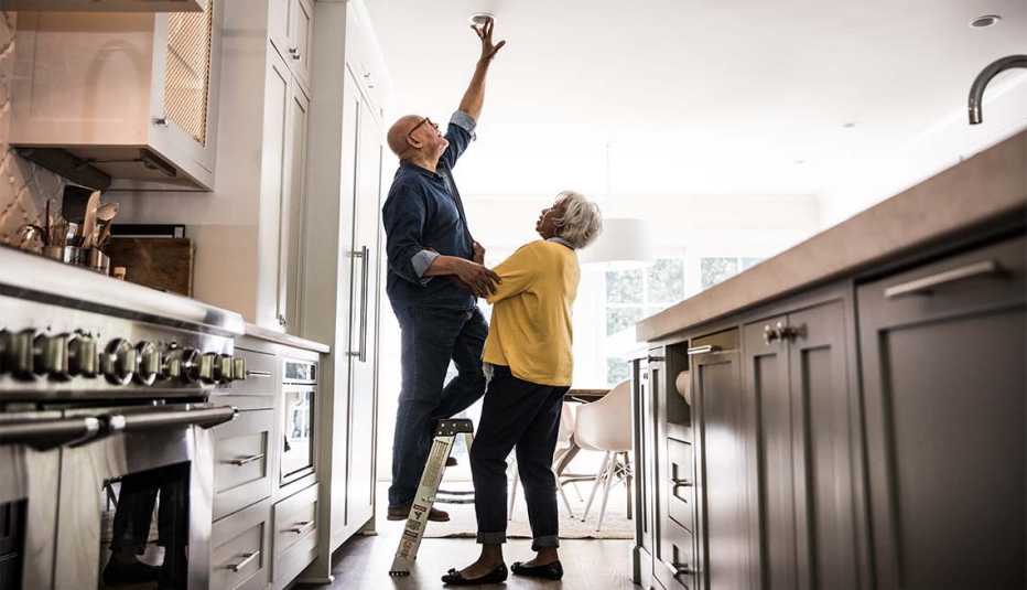 Una pareja de adultos mayores hace arreglos en la casa