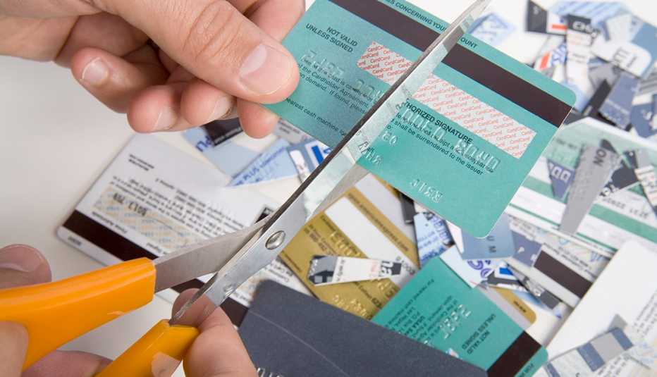 Persona cortando tarjetas de crédito