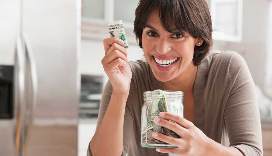 Mujer sosteniendo billetes de dólares en sus manos.