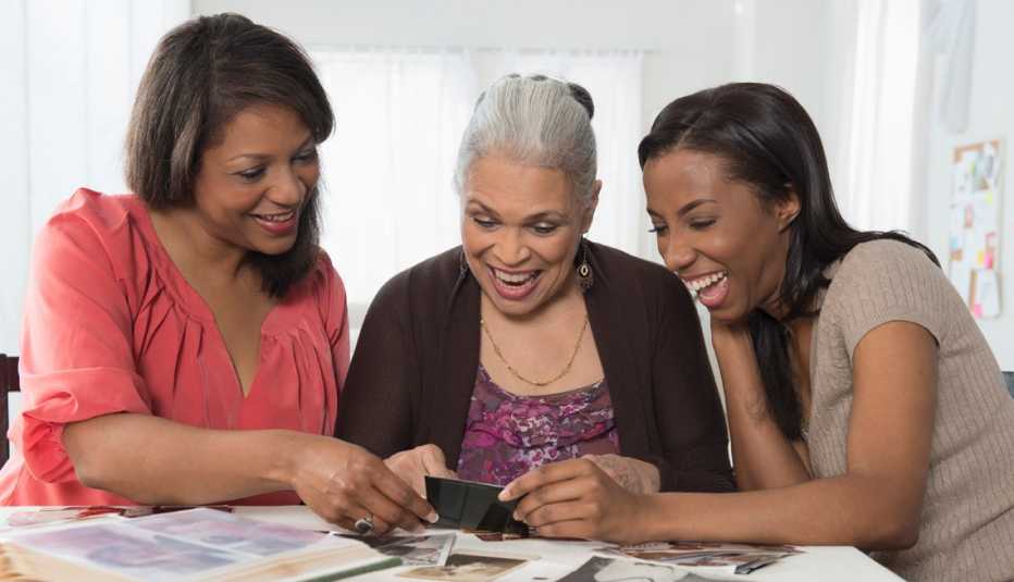 Tres generaciones de mujeres viendo fotos