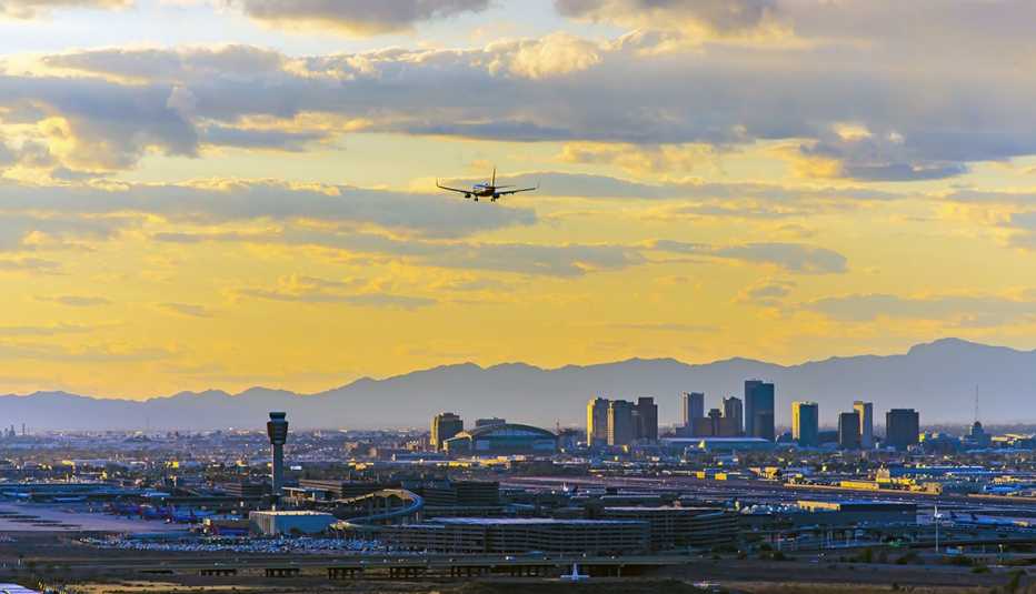 Vista general de Phoenix, Arizona, al atardecer con un avión que la sobrevuela.
