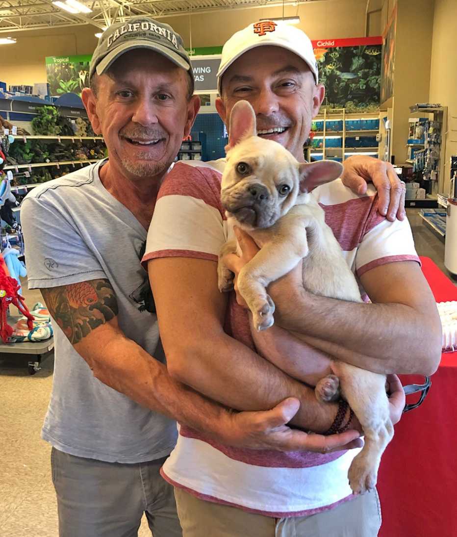 Craig Bradley y Troy Withers en una tienda de mascotas con su perrito