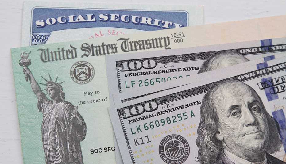 Tarjeta del Seguro Social, detrás de un cheque del Departamento del Tesoro de EE.UU. y dos billetes de $100 dólares.