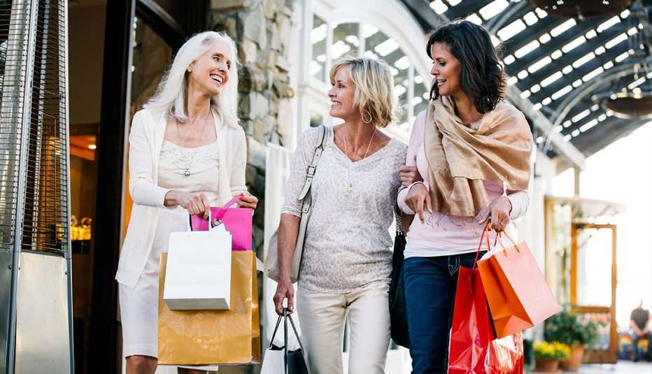 Un grupo de mujeres caminan mientras hacen compras.