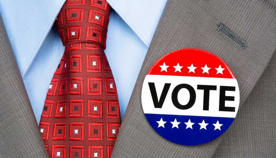 Un hombre lleva un botón de las elecciones en la solapa de su traje.