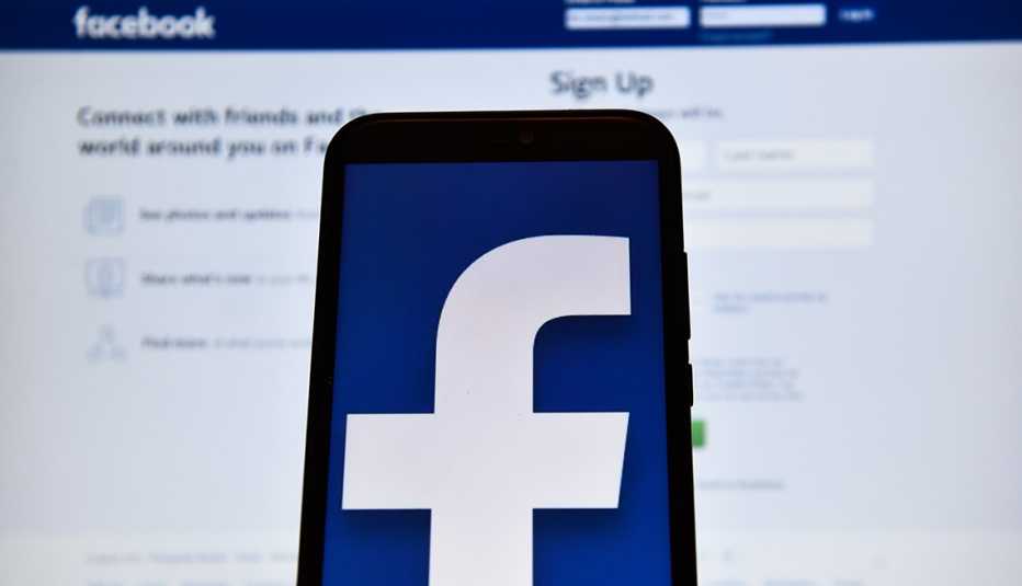 Logo de Facebook en la pantalla de un iPhone y un computador