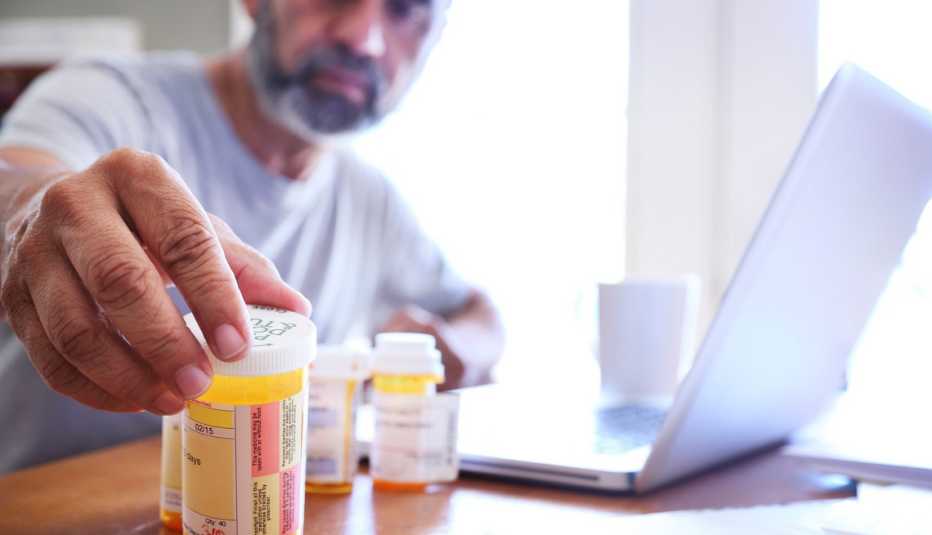 Hombre observa unos recipientes con medicamentos