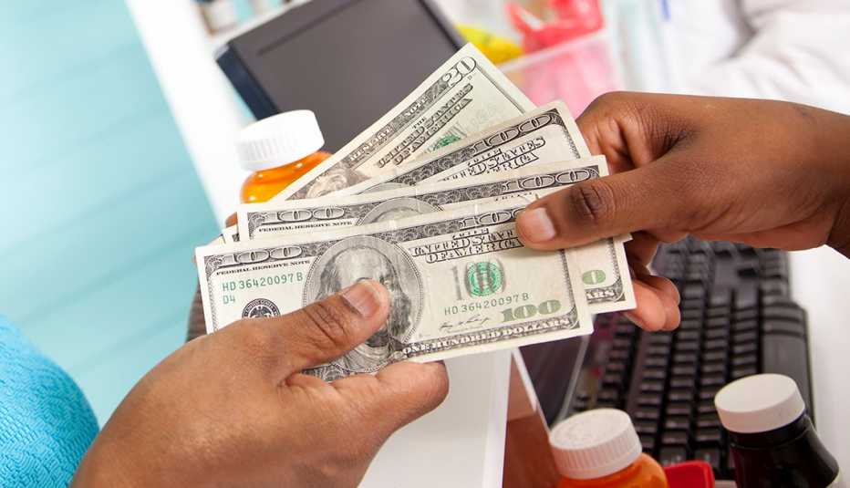Persona paga con dinero por su medicamento recetado