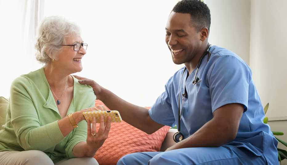 Enfermero sonríe con una paciente mayor