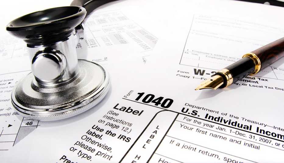 Formularios de impuestos con un bolígrafo y un estetoscopio
