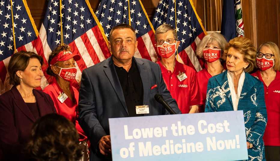 Larry Zarzecki habla en una conferencia de prensa sobre la reducción de los precios de los medicamentos con senadores de los Estados Unidos y voluntarios de AARP