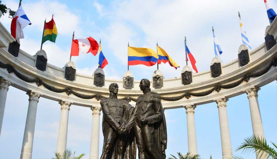 Banderas ondean junto a la estatua de Simón Bolívar y San Martín de los Andes en Guayaquil, Ecuador.
