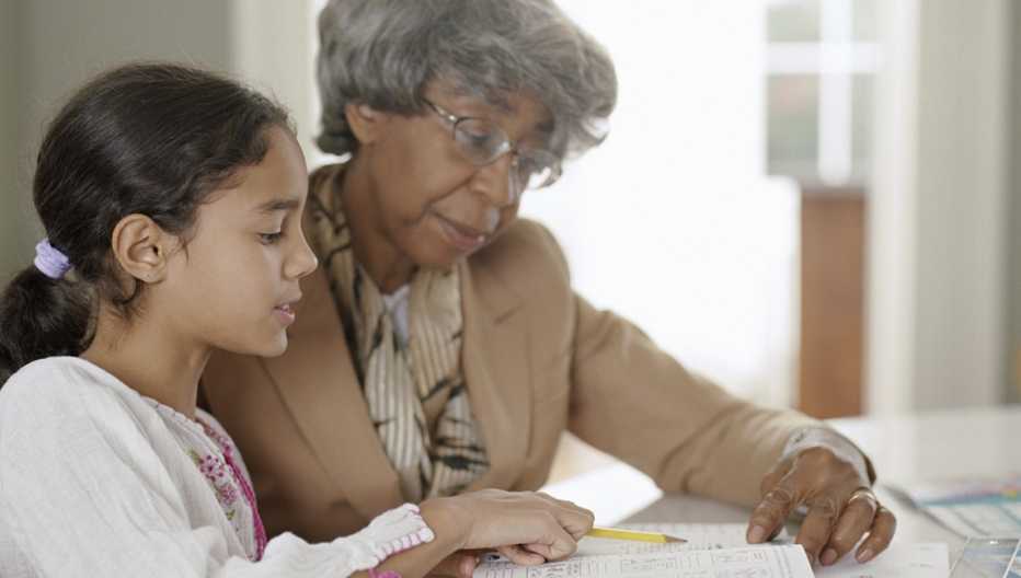 Abuela ayuda a su nieta con la tarea.