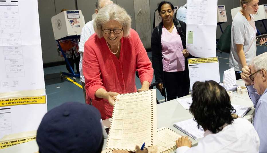 Mujer mayor recibe unos documentos mientras se alista a votar en las elecciones de mitad de mandato de 2018.