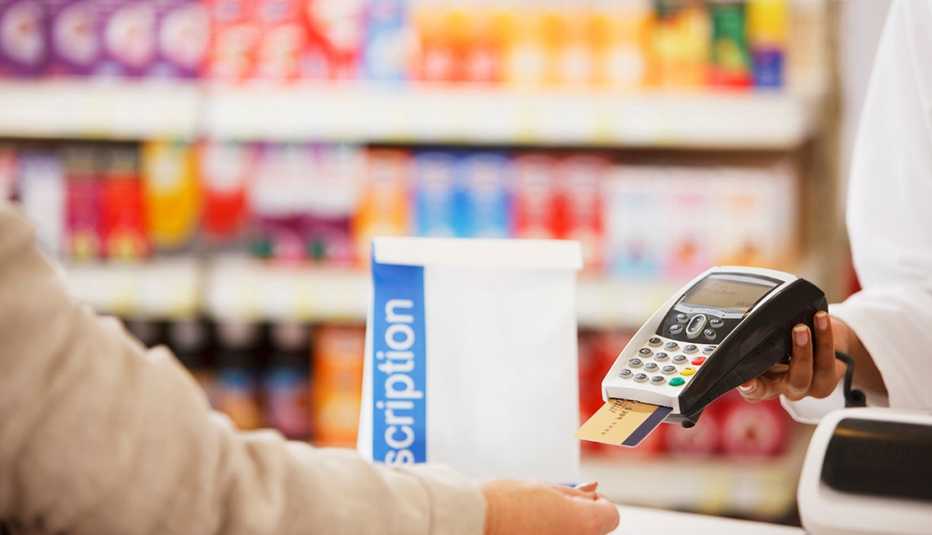 Una persona paga un medicamento con una tarjeta de crédito