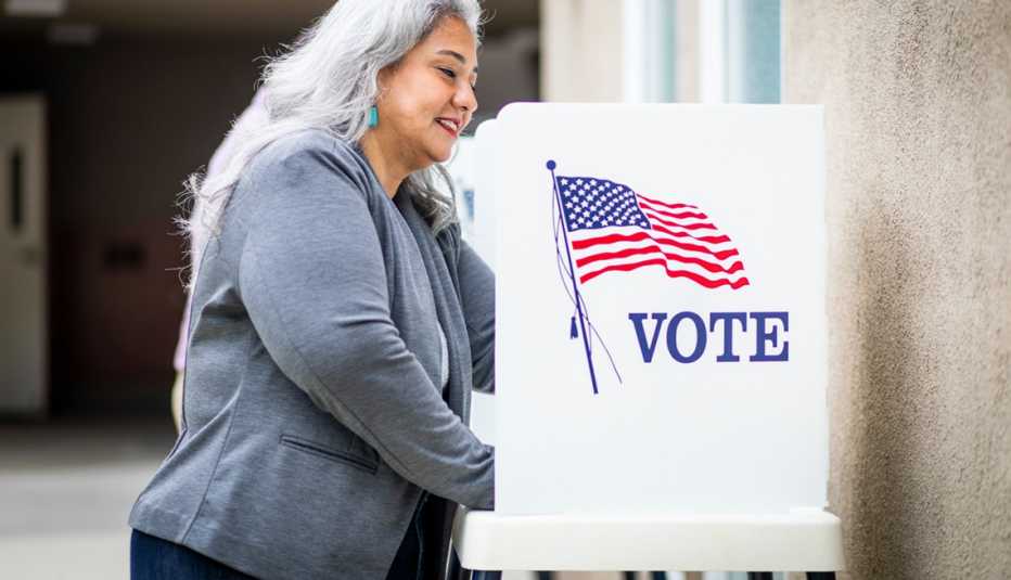 Mujer sonríe en una cabina de votación