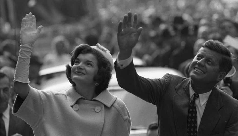 Jackie y John F Kennedy saludan a la multitud